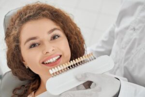 a lady dentist checking dental crowns on a patient